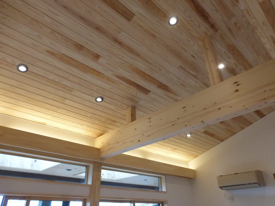 勾配天井には無垢の杉を貼っています。間接照明とダウンライトが広がりを感じさせます。
