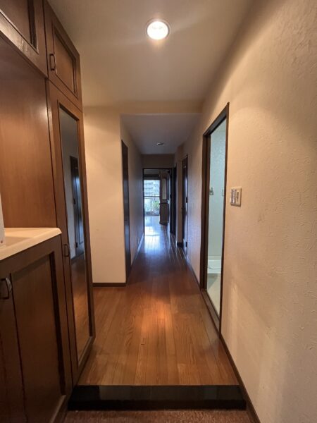 ブラウンの建具と床でまとめられた落ち着いた玄関。経年により全体的に暗い印象となっていました